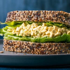 Vegan egg salad on whole wheat bread with lettuce.