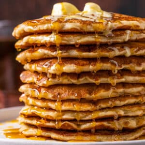 Stack of vegan oatmeal pancakes with vegan butter and syrup.