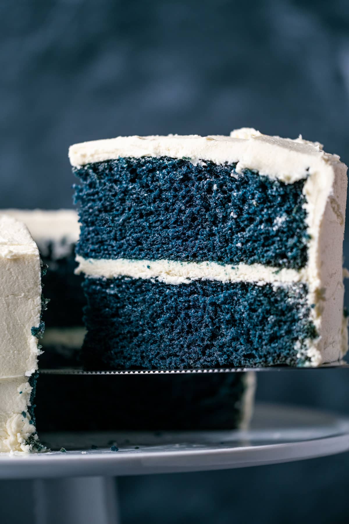 Slice of vegan blue velvet cake on a cake lifter.