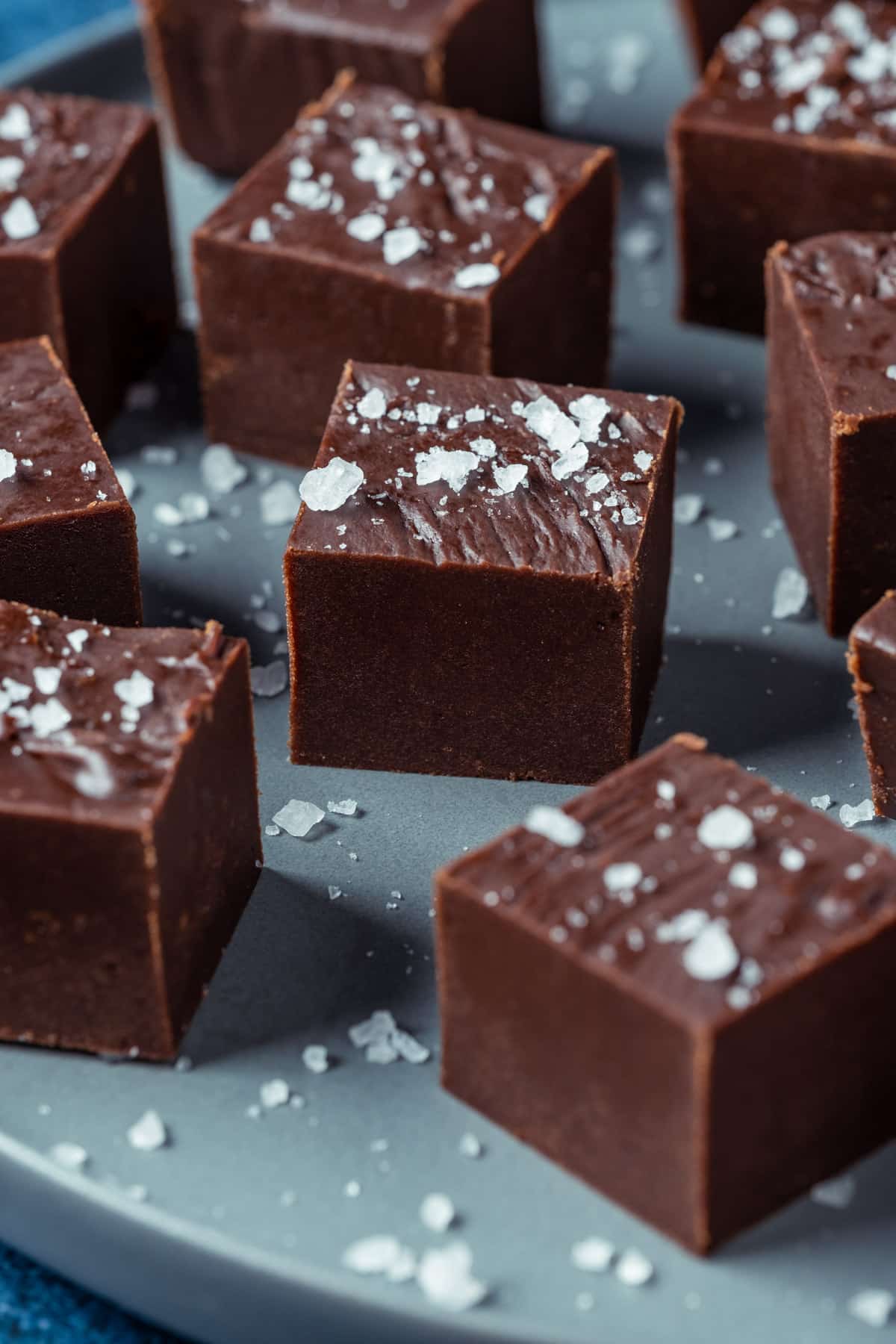 Squares of vegan fudge on a gray plate.