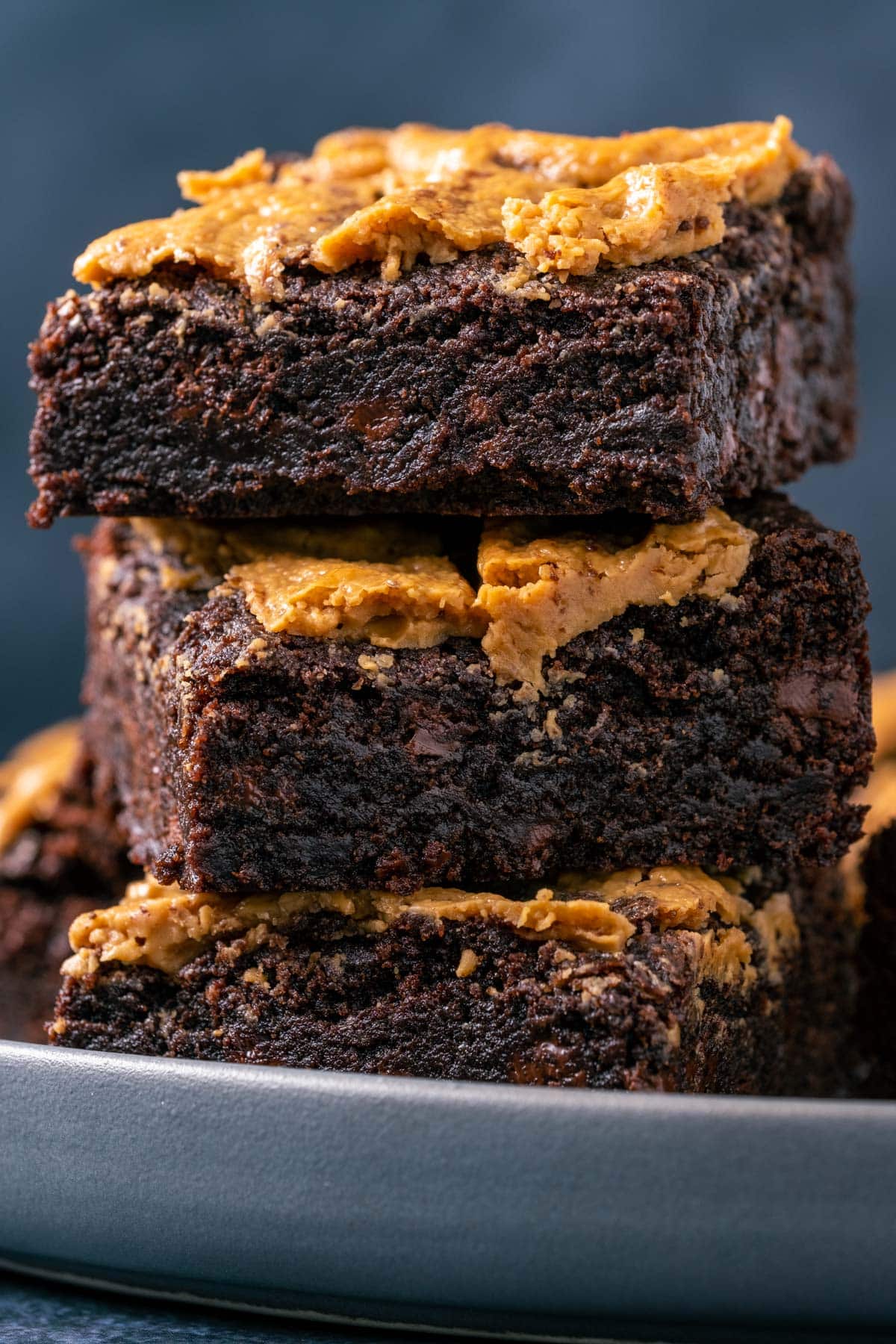 Stack of three brownies on a plate.
