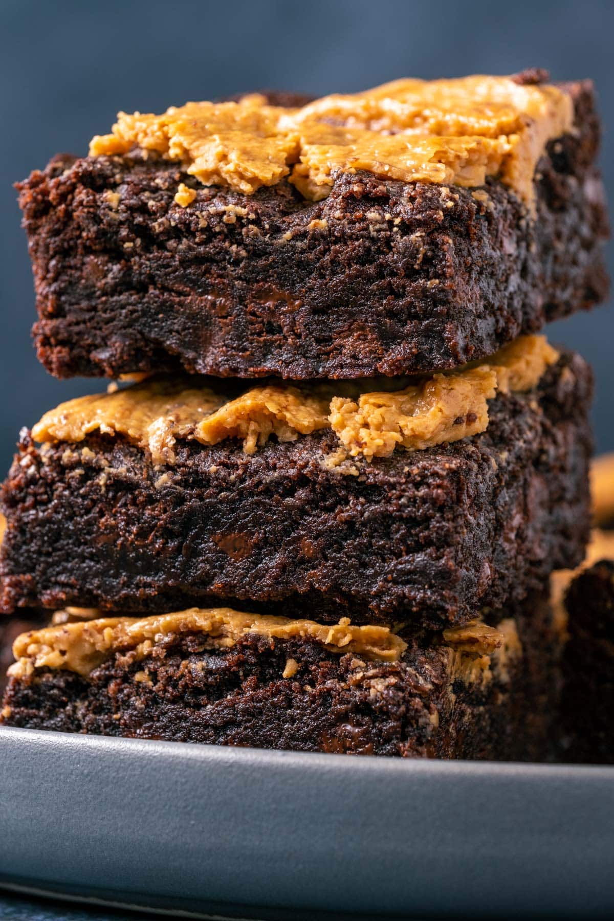 Vegan peanut butter brownies stacked up on a plate. 