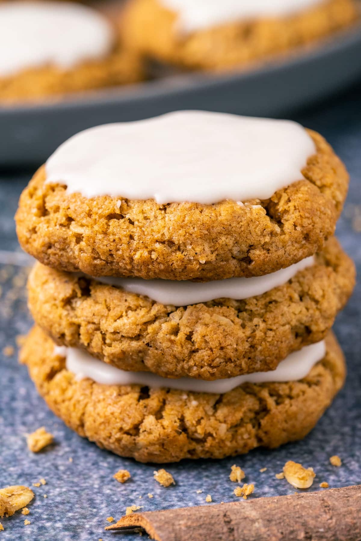 A stack of three frosted oatmeal cookies.