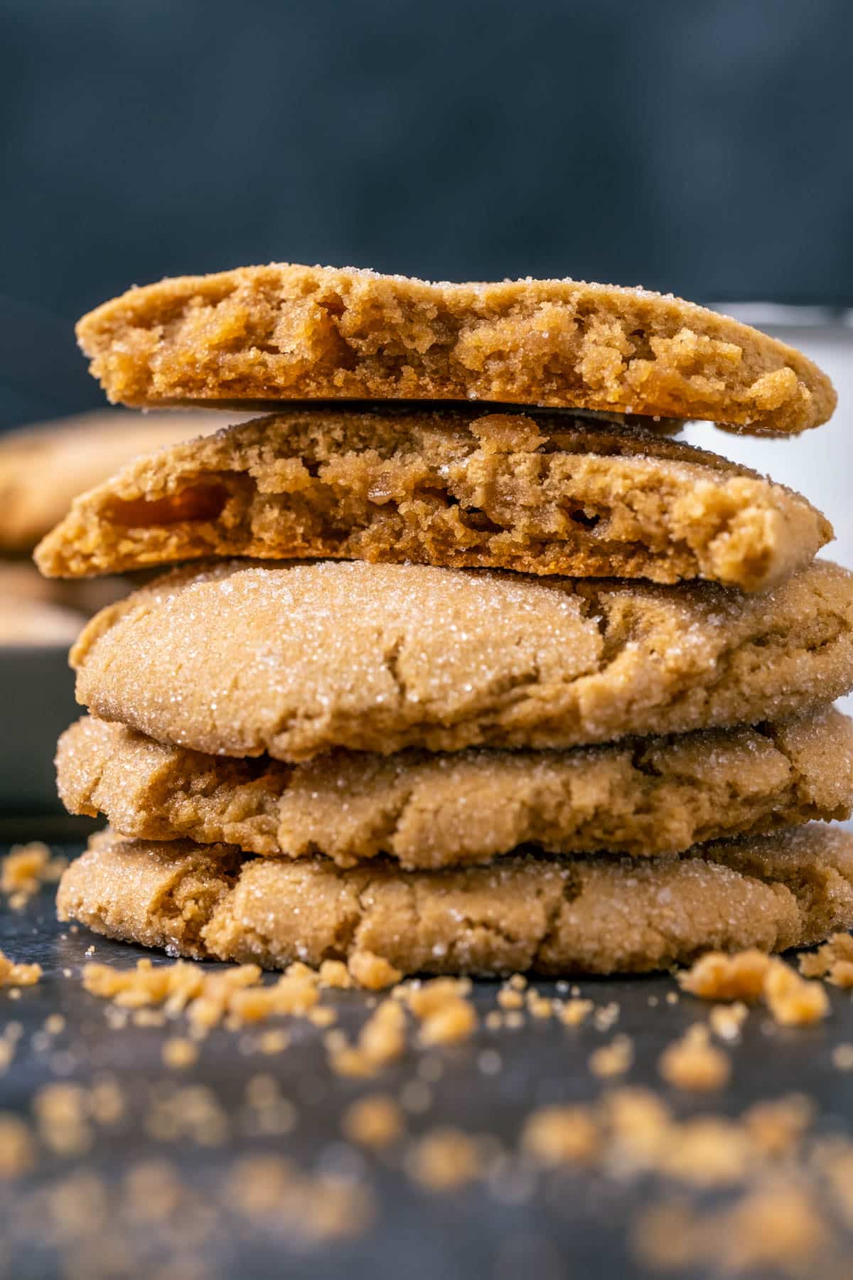 A stack of vegan brown sugar cookies with the top cookie broken in half.
